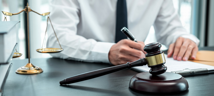 Attorney reviewing legal content at a desk with a gavel and justice scales, representing law firm blog strategy and content repurposing.