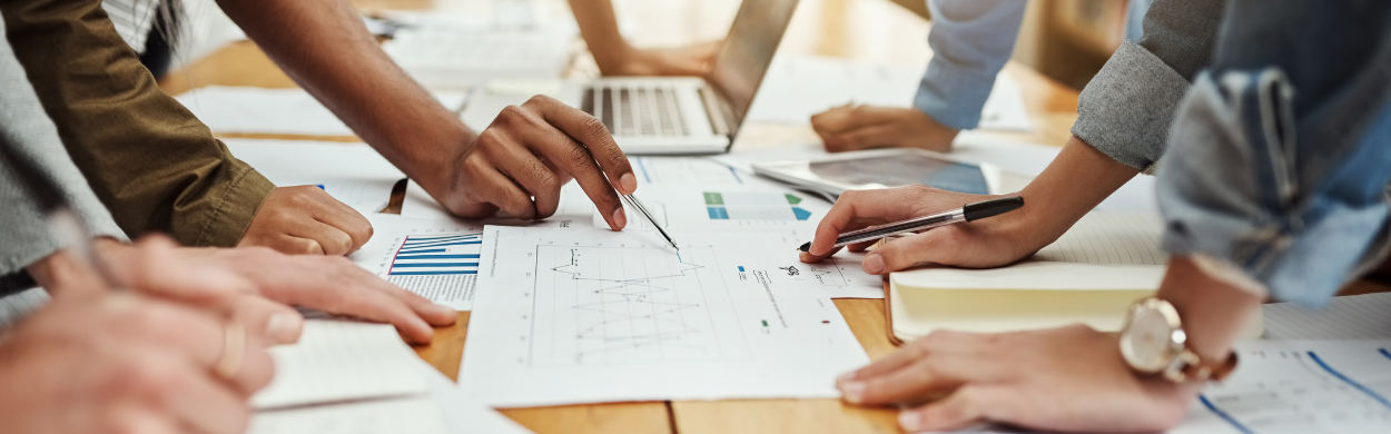 Team collaboration on business data analysis with charts, graphs, and reports, showcasing the success of client case studies and results-driven strategies at Top of Mind PR