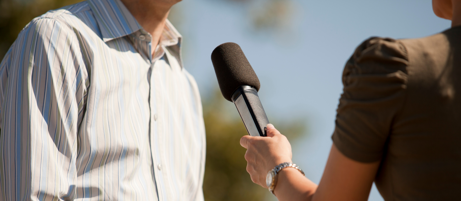 Woman holding up microphone to man