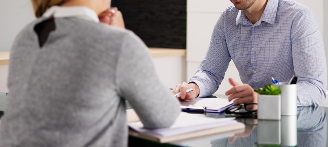PR advisor reviewing documents with a client during a strategic meeting about reputation management and communication planning