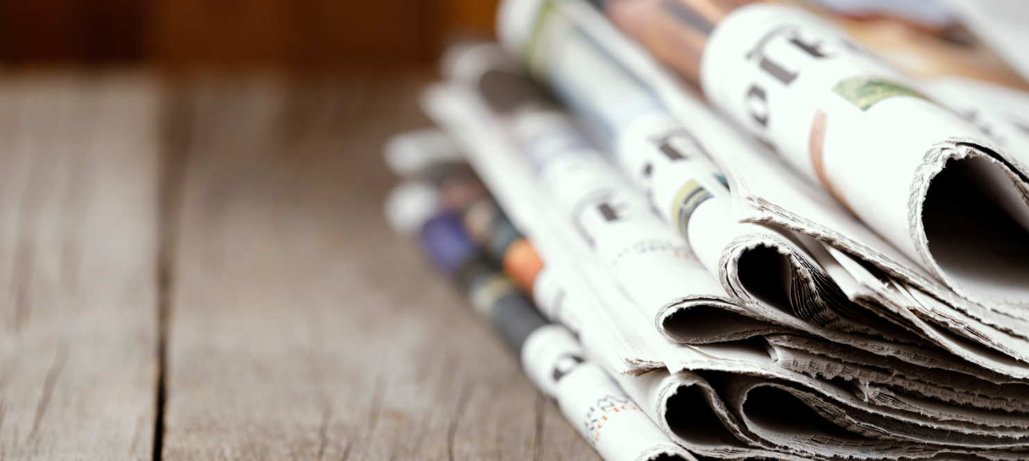 Stack of newspapers representing media visibility and public relations for mission-driven organizations.